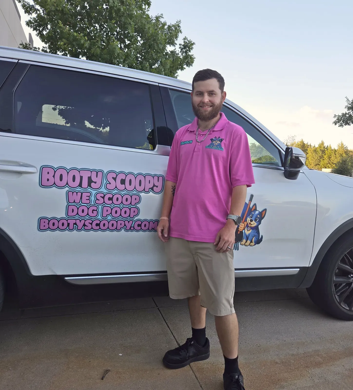 Brandon standing beside the Booty Scoopy SUV, lettered We Scoop Dog Poop