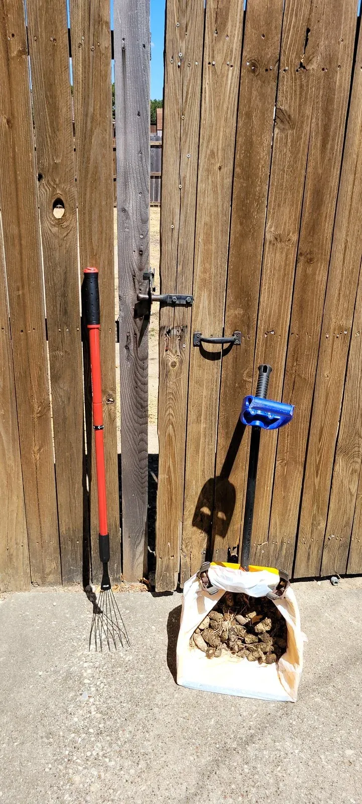 A full scoop pan, rake and scooper by a customer's gate after a cleanup
